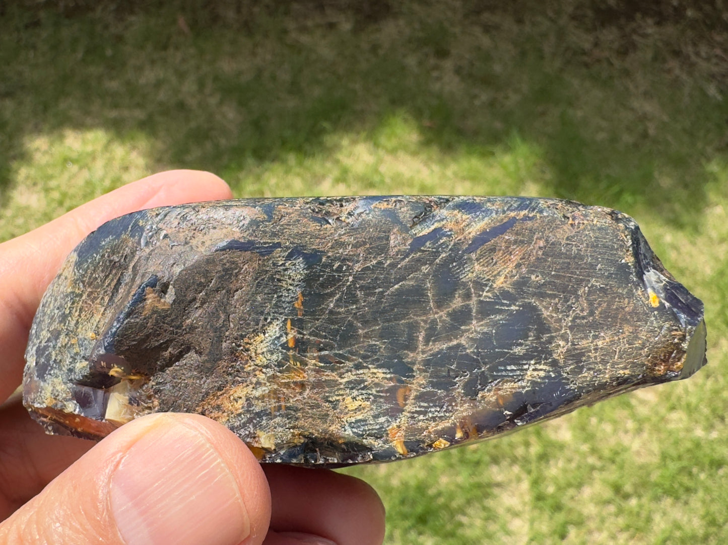 ブルーアンバー原石の背面。多くの土状の被膜が残っており、自然の風化や地中の痕跡をそのまま感じられる質感。