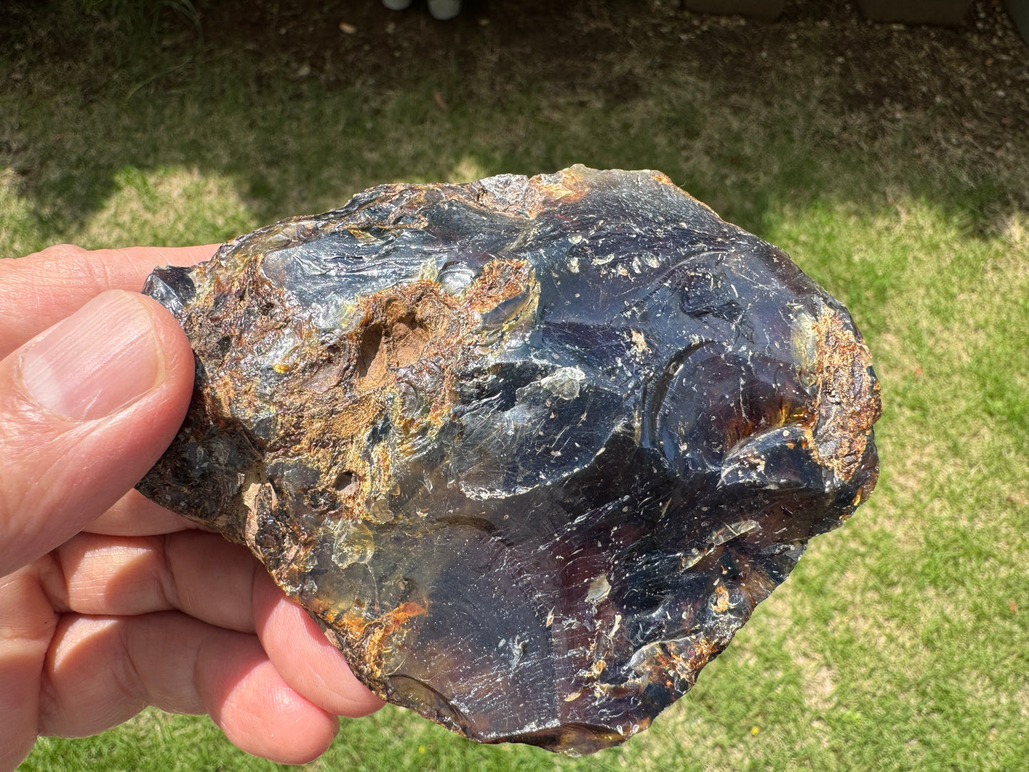 磨かれたような艶のあるブルーアンバーの一面。インクルージョンの存在が浮かび上がり、まるで地中に埋もれた時間の層を覗き込むような印象。