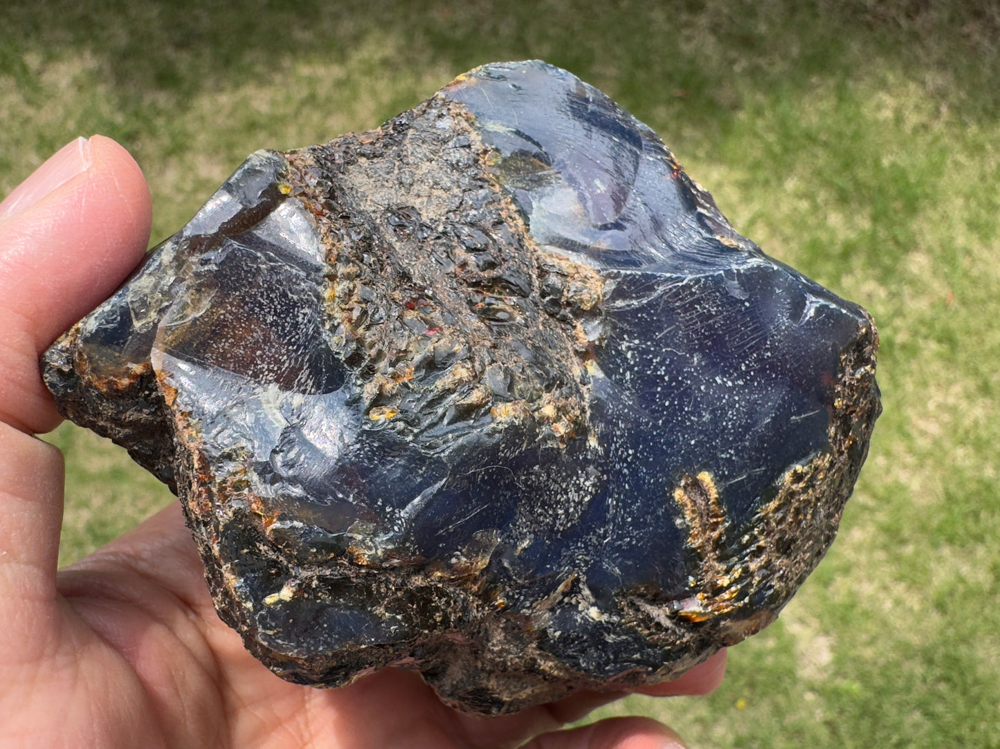 太古の樹皮のような質感と深い青が印象的なブルーアンバー原石。中央に植物繊維を思わせるインクルージョンが浮かび上がっている。
